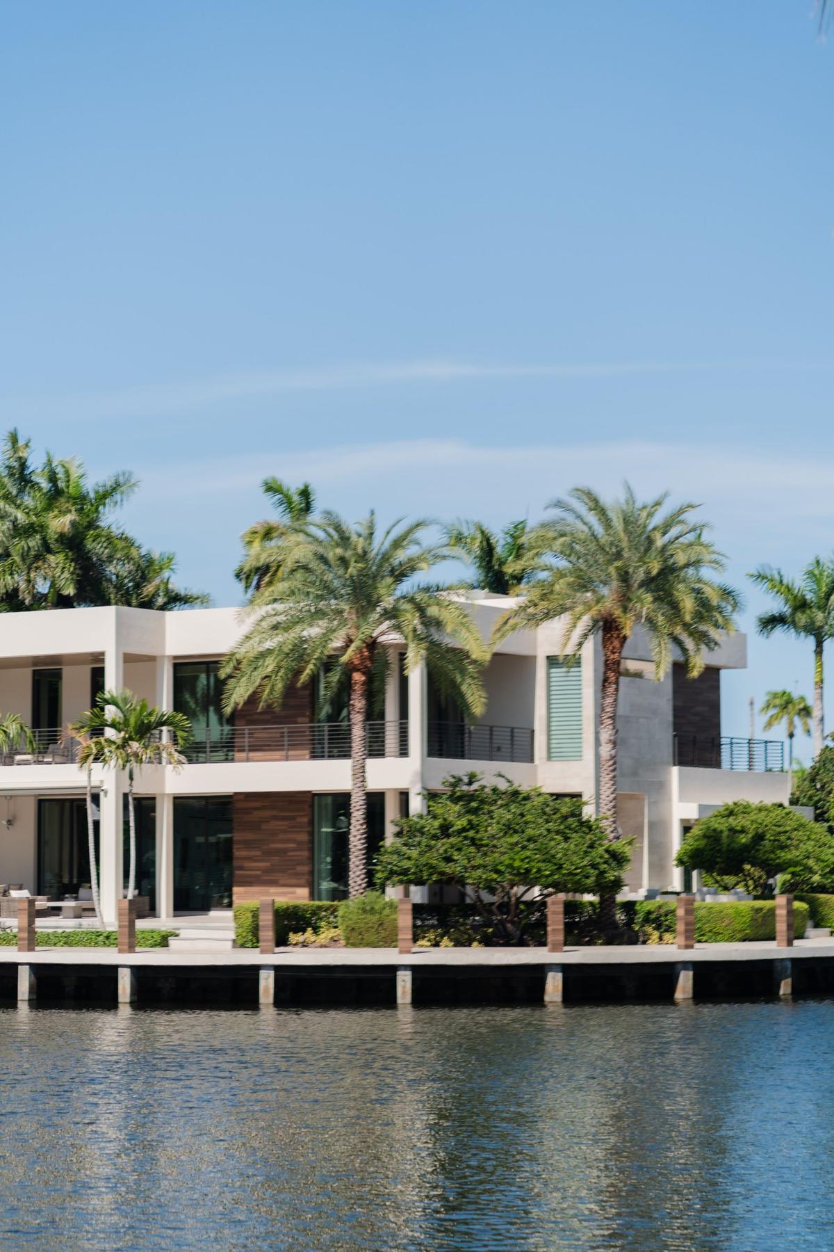 Modern waterfront home with palm trees